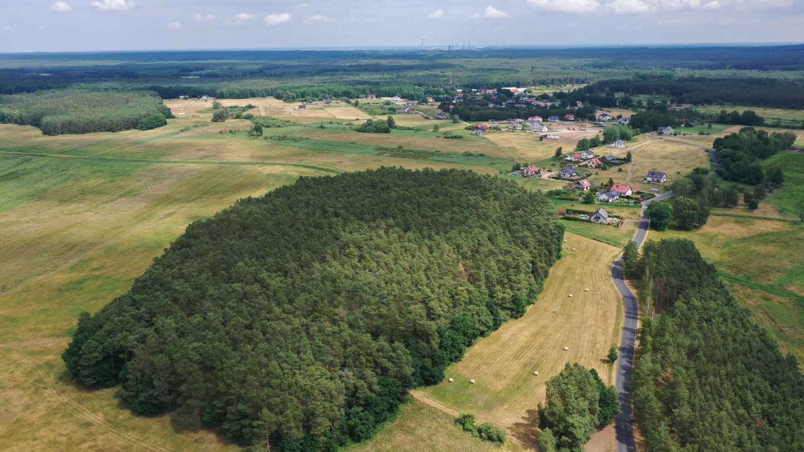 Widok z drona na wieś Sławoszewo, otaczające ją pola i las